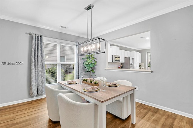 dining space with hardwood / wood-style flooring, crown molding, and a wealth of natural light