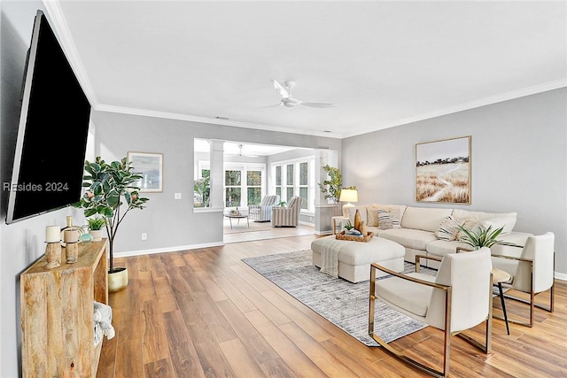 living room with hardwood / wood-style flooring, ceiling fan, and ornamental molding