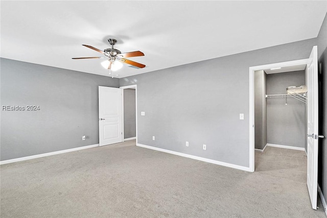 unfurnished bedroom featuring light carpet, ceiling fan, and a closet