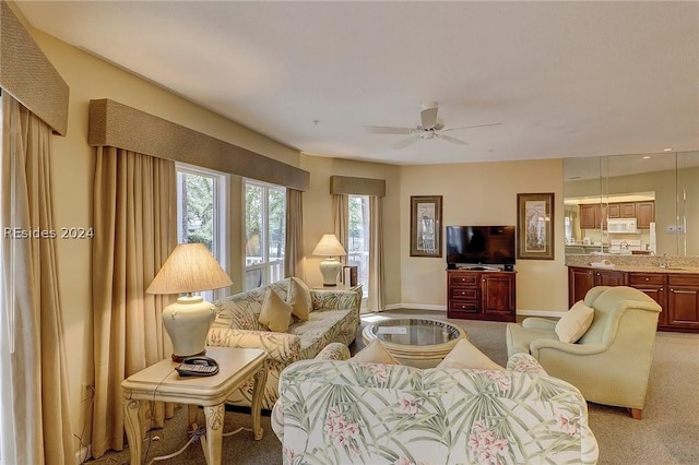 carpeted living room featuring sink and ceiling fan