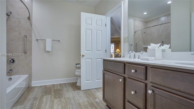 full bathroom featuring vanity, tiled shower / bath combo, and toilet