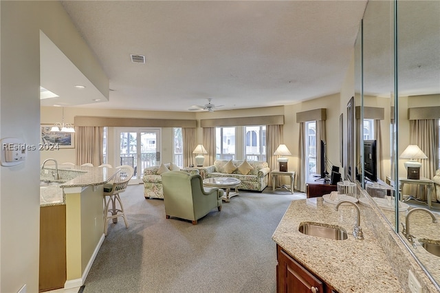 living room with sink, carpet floors, and a textured ceiling