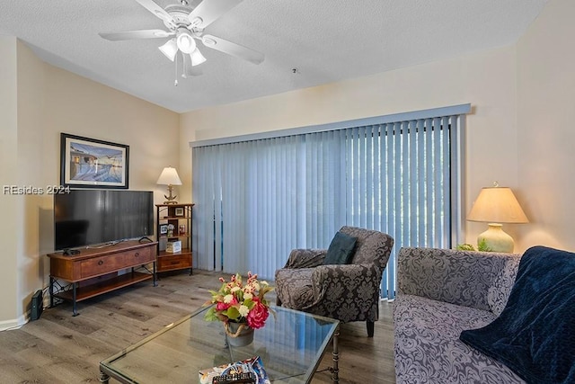 living room featuring hardwood / wood-style floors, a textured ceiling, and ceiling fan