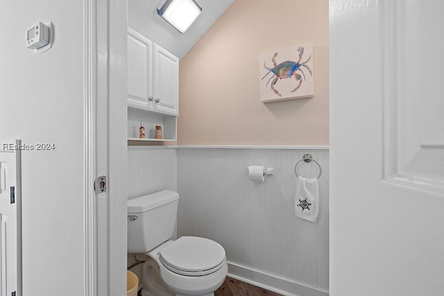 bathroom featuring toilet, vaulted ceiling, and hardwood / wood-style floors