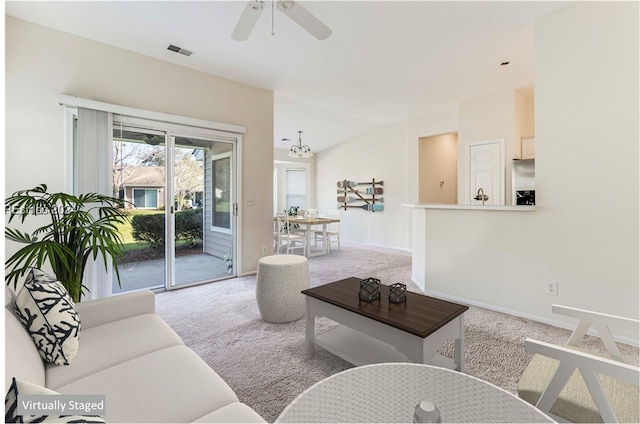 carpeted living room with vaulted ceiling and ceiling fan with notable chandelier