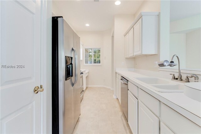 kitchen with stainless steel appliances, sink, and white cabinets