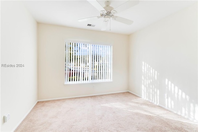 spare room featuring ceiling fan and light carpet