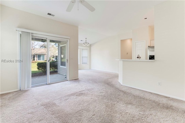 unfurnished living room featuring ceiling fan with notable chandelier, light carpet, and lofted ceiling