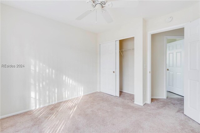 unfurnished bedroom featuring light colored carpet, ceiling fan, and a closet