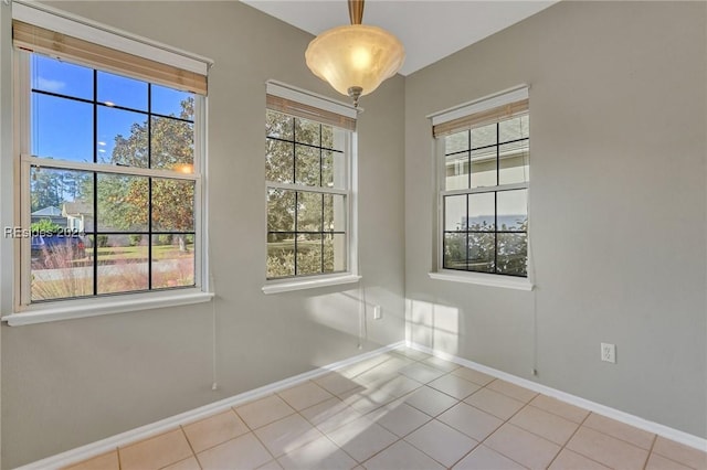 spare room featuring a healthy amount of sunlight and light tile patterned flooring