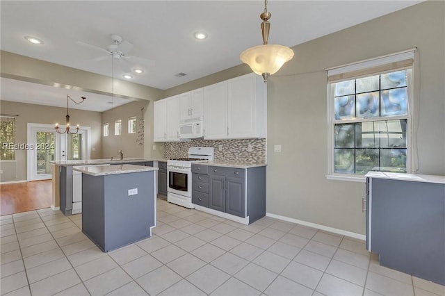 kitchen with pendant lighting, white appliances, gray cabinetry, tasteful backsplash, and white cabinets