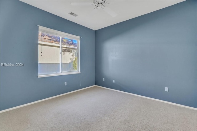 carpeted spare room with ceiling fan