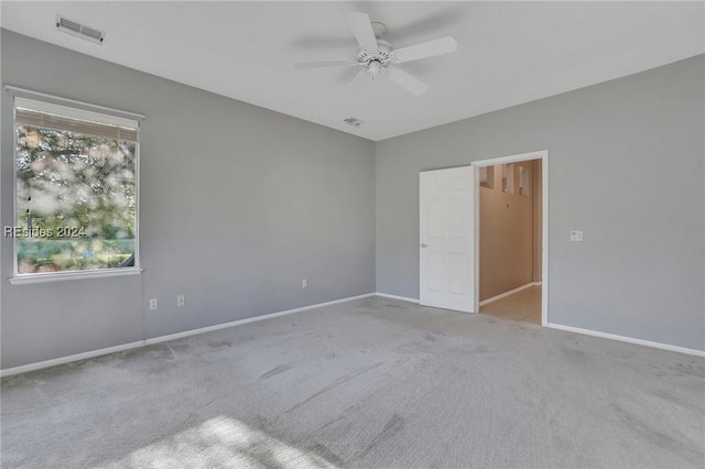 empty room featuring light colored carpet and ceiling fan