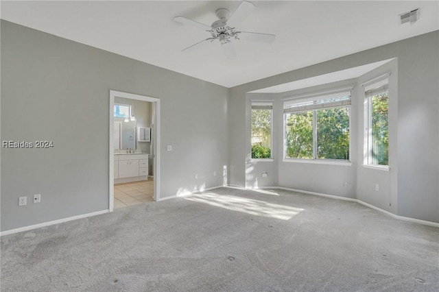 carpeted spare room featuring ceiling fan