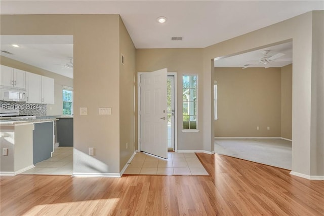 entrance foyer with ceiling fan, plenty of natural light, and light wood-type flooring