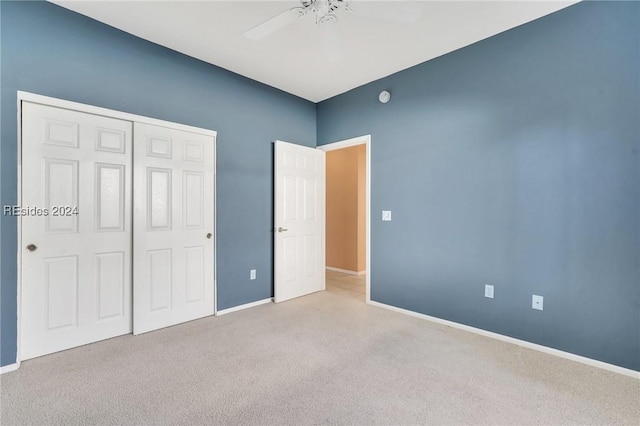 unfurnished bedroom with light carpet, ceiling fan, and a closet