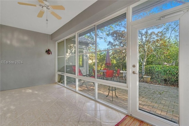 doorway with light tile patterned flooring and ceiling fan