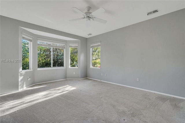 empty room with light colored carpet and ceiling fan