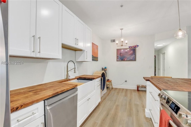 kitchen with white cabinetry, butcher block countertops, hanging light fixtures, and appliances with stainless steel finishes