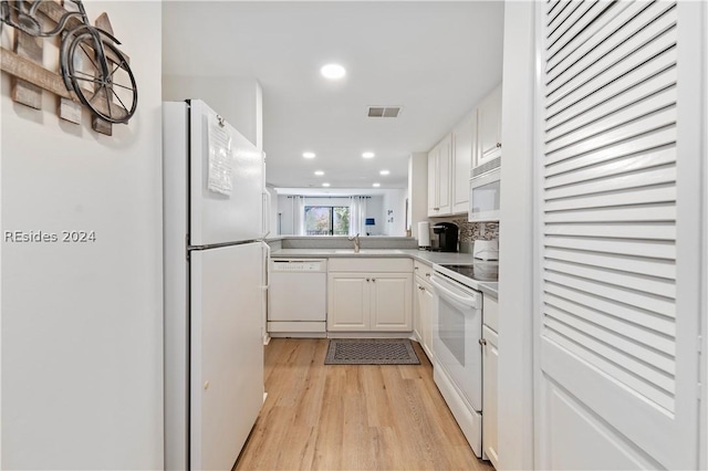 kitchen featuring light wood-type flooring, white appliances, sink, and white cabinets