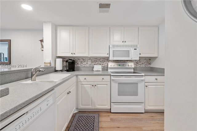 kitchen featuring sink, white appliances, white cabinetry, decorative backsplash, and light wood-type flooring