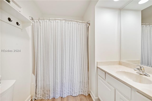 full bathroom with hardwood / wood-style flooring, vanity, toilet, and shower / bath combo