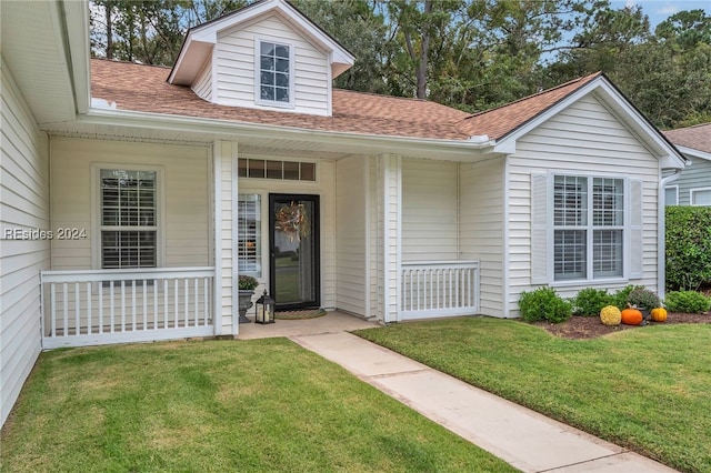 property entrance featuring a lawn and covered porch