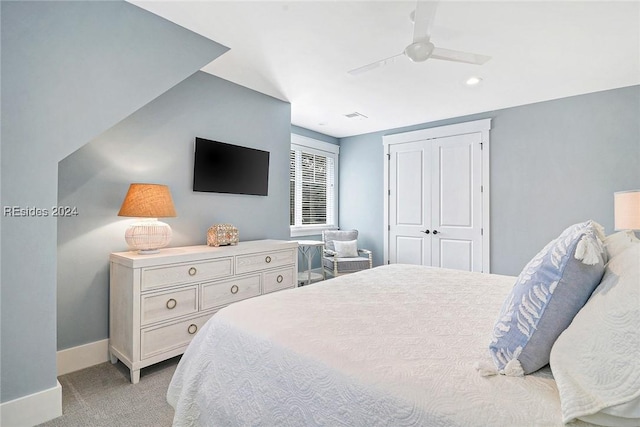 bedroom featuring light colored carpet, a closet, and ceiling fan