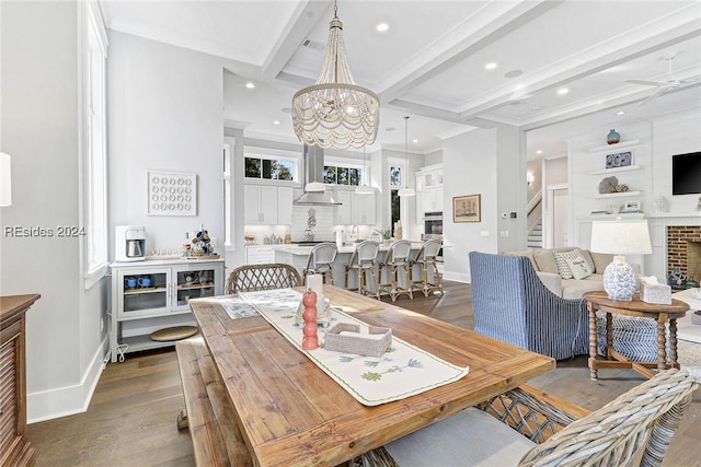 dining space featuring beamed ceiling, crown molding, dark hardwood / wood-style floors, and a fireplace