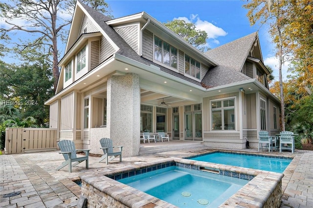 rear view of house with a patio, ceiling fan, and an in ground hot tub