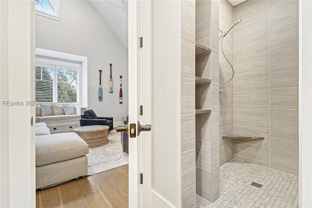 bathroom with hardwood / wood-style flooring and a tile shower