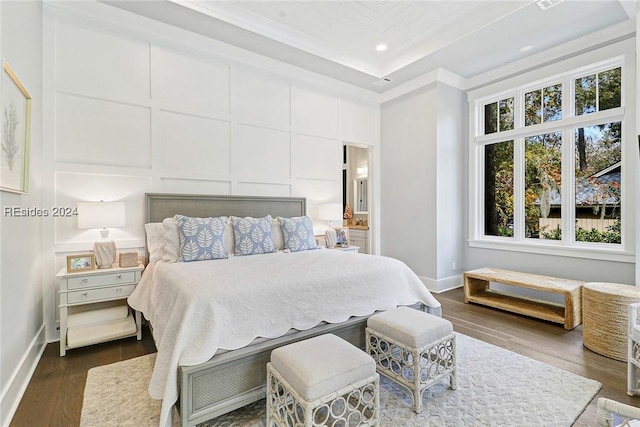 bedroom with ornamental molding and dark hardwood / wood-style floors