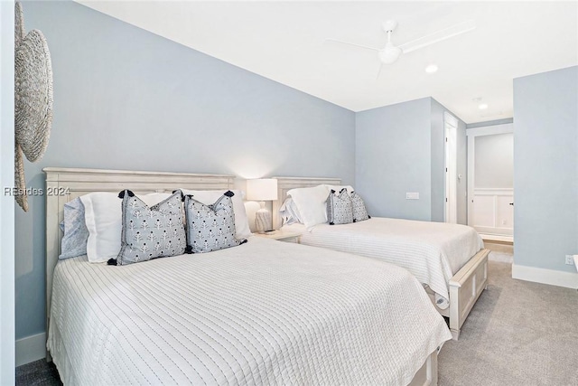 bedroom with ceiling fan, light carpet, and ensuite bath