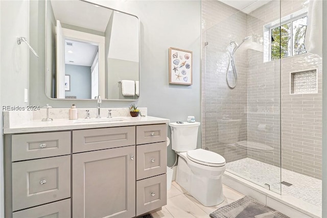 bathroom featuring tiled shower, vanity, toilet, and tile patterned floors