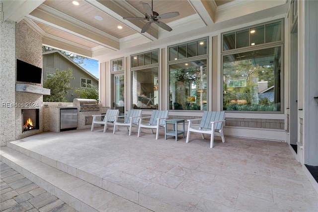 view of patio featuring ceiling fan, a large fireplace, grilling area, and exterior kitchen