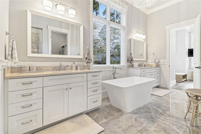 bathroom with vanity, ornamental molding, and a tub