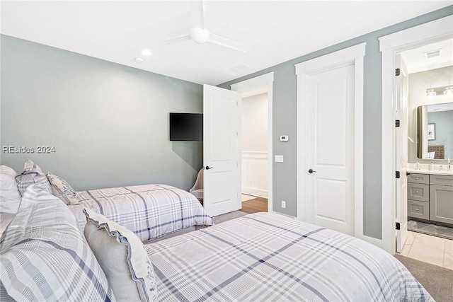 carpeted bedroom featuring ceiling fan and ensuite bath