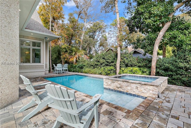 view of pool with an in ground hot tub and a patio