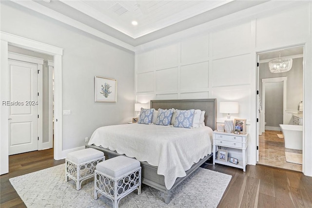 bedroom featuring ensuite bathroom, dark hardwood / wood-style floors, and a notable chandelier