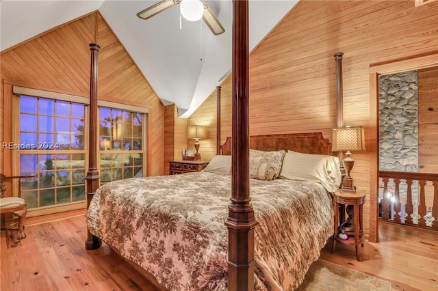 bedroom with ceiling fan, high vaulted ceiling, light hardwood / wood-style floors, and wood walls