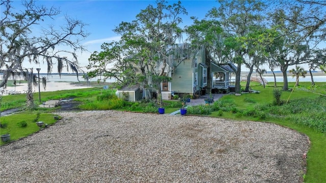 view of side of home featuring a water view and a lawn