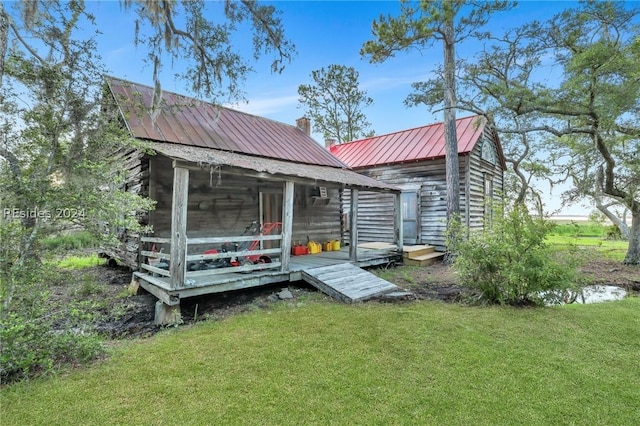 rear view of property with a yard and an outbuilding