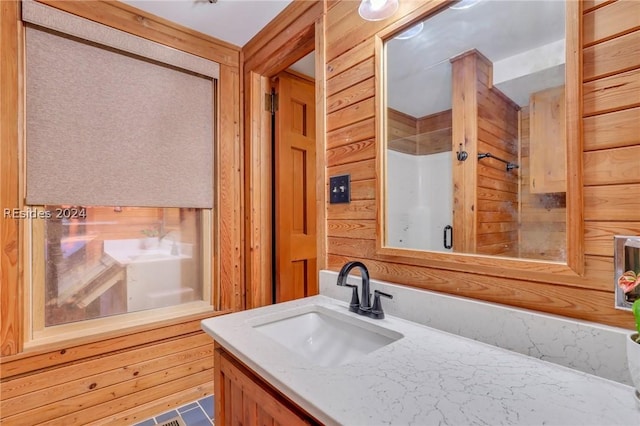 bathroom featuring tile patterned floors, vanity, and wood walls