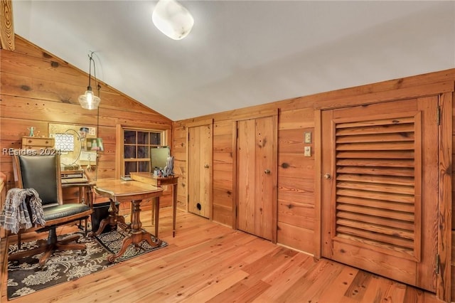 office space featuring lofted ceiling, light hardwood / wood-style floors, and wood walls