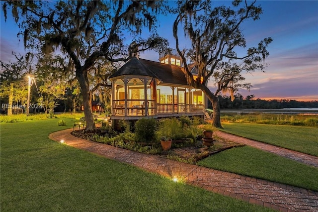 back house at dusk featuring a yard