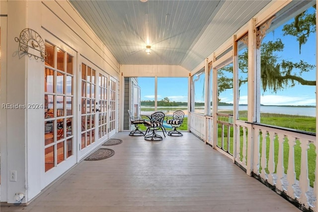 sunroom / solarium featuring a water view and vaulted ceiling