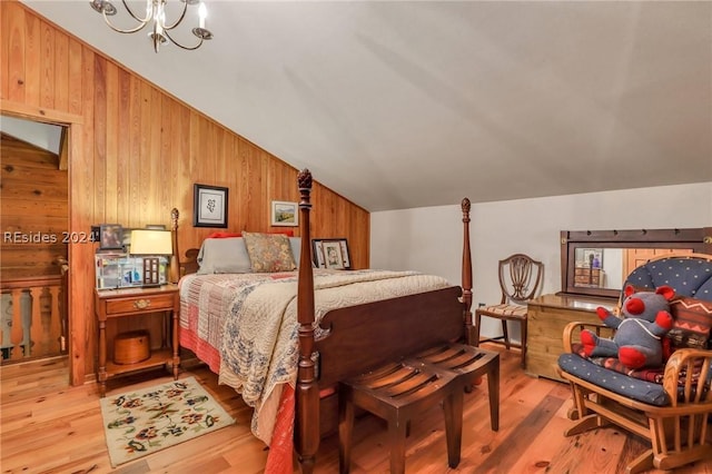 bedroom featuring lofted ceiling, light hardwood / wood-style flooring, and a notable chandelier