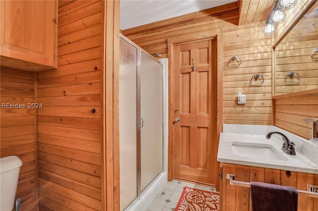 bathroom featuring vanity, a shower with shower door, toilet, and wood walls