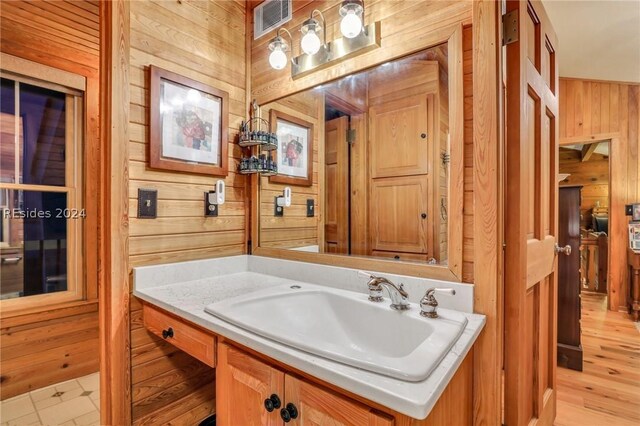 bathroom featuring vanity and wooden walls