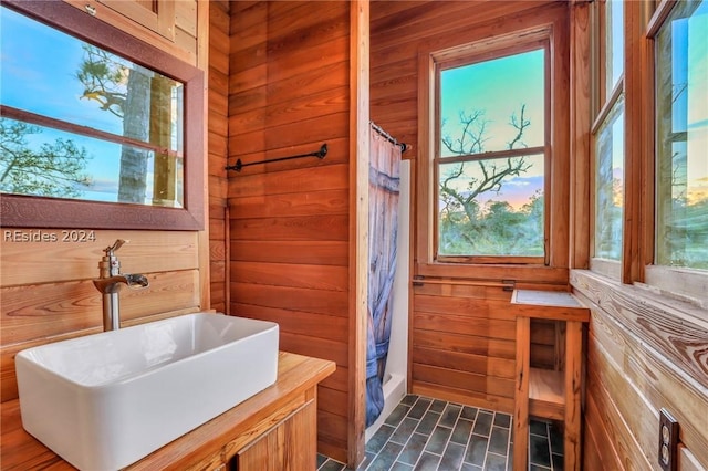 bathroom with walk in shower, wooden walls, and a wealth of natural light